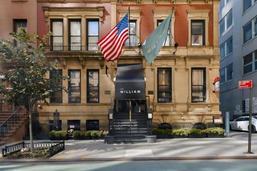 two flags flying in front of a building at The William Hotel Midtown, Sonder by Marriott Bonvoy in New York