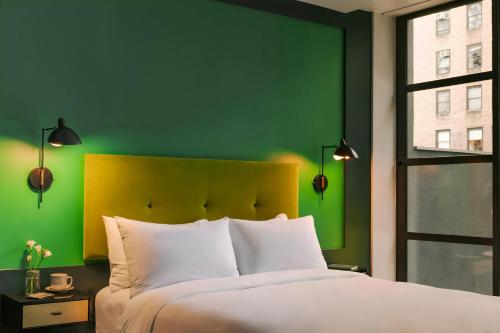 a bedroom with a green wall and a bed at The William Hotel Midtown, Sonder by Marriott Bonvoy in New York