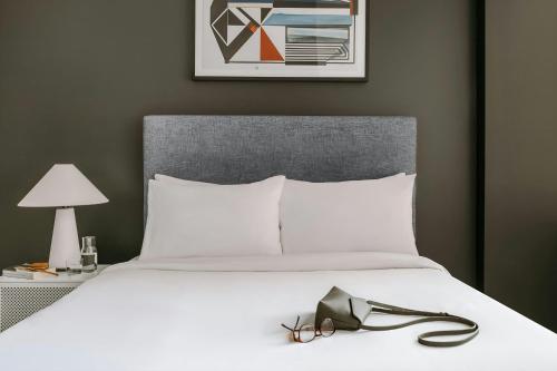 a white bed with a pair of glasses on it at Sonder by Marriott Bonvoy Battery Park Apartments Financial District in New York