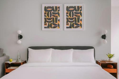 a bedroom with a white bed with two pictures on the wall at Sonder by Marriott Bonvoy Battery Park Apartments Financial District in New York