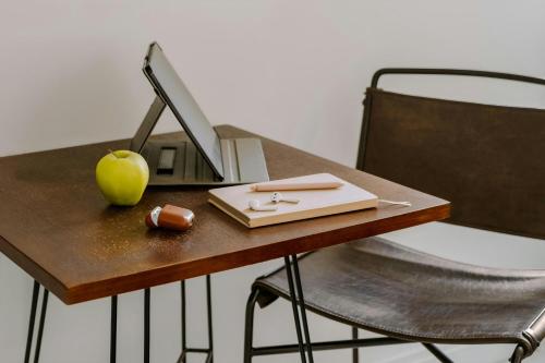a desk with a computer and an apple on it at Sonder by Marriott Bonvoy Battery Park Apartments Financial District in New York