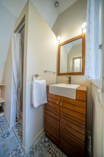 une salle de bain avec un lavabo et un miroir dans l'établissement chaumière typique bretonne, à Carnac