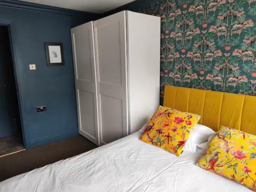 a bedroom with a white bed with two pillows at Cotswold Stay in Burford