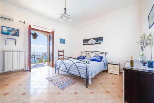 1 dormitorio con cama y vistas al océano en L'Uliveto, en Positano