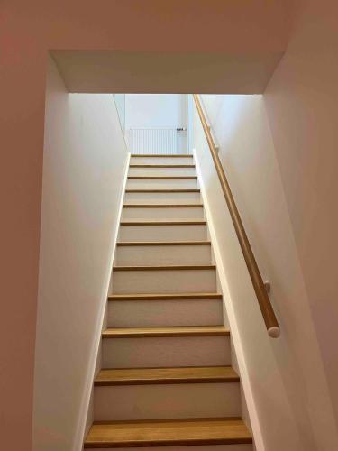 a staircase in a house with white walls and wooden stairs at Beautifu Villa Agathe Carnac in Carnac