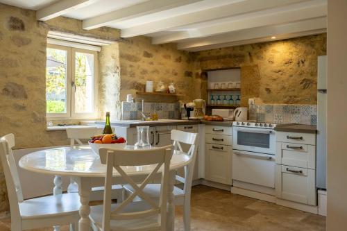 une cuisine avec une table et des chaises dans une pièce dans l'établissement chaumière typique bretonne, à Carnac