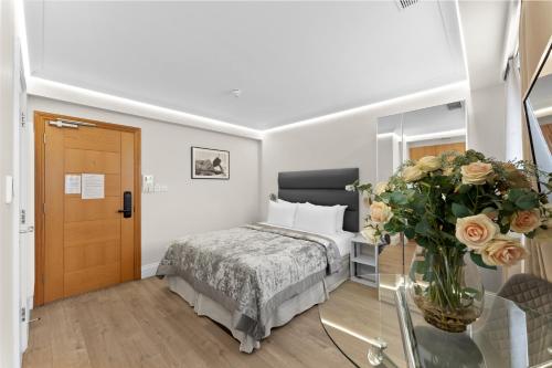 a bedroom with a bed and a vase of flowers at Cleveland Residences Russell Square in London