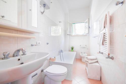 bagno bianco con lavandino e servizi igienici di L'Uliveto a Positano