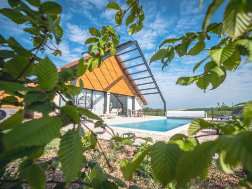 une maison avec un toit en métal et une piscine dans l'établissement Coeur Au Bois, à Laubressel
