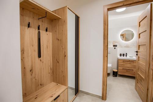 a bathroom with a wooden door and a sink at Hron River Apartment in Brezno