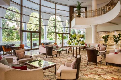 a lobby with tables and chairs and large windows at DLF Club 5 in Gurgaon