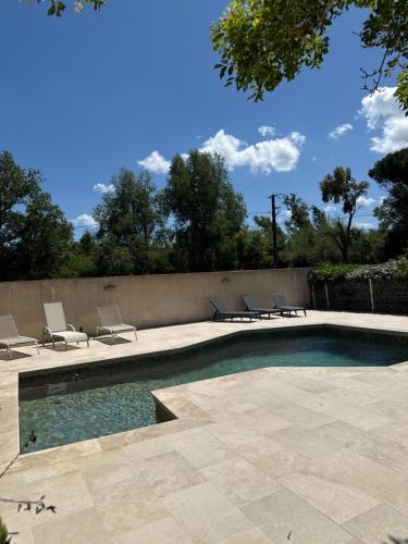 - une piscine avec des chaises longues à côté d'un mur dans l'établissement casa SamaSama, à Porto-Vecchio