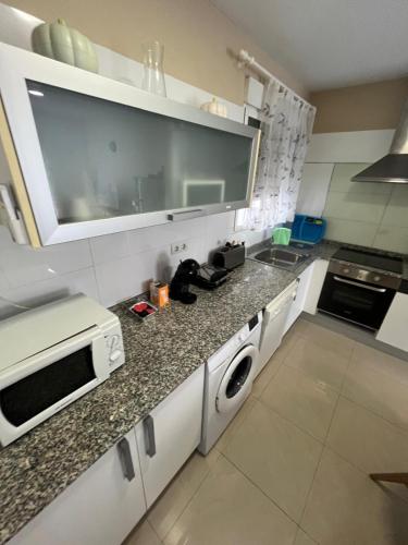 a kitchen with a sink and a microwave at ÁTICO HOME y Garaje, Algemesi Home in Algemesí