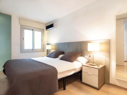a bedroom with a large bed and a window at Rent Top Apartments Rambla Catalunya in Barcelona