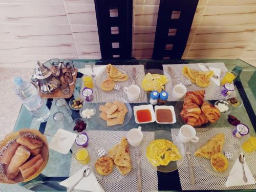 a table with a bunch of different types of food at Magnifique maison famiiale moderne spacieuse de 150 m Avec de 3 chambres ,confortables et d un grand salon et terrasse, Idealement situee a 9 min du centre-ville elle se trouve à proximite de la route principale menant a l aeroport Berkane et Saidia in Oujda