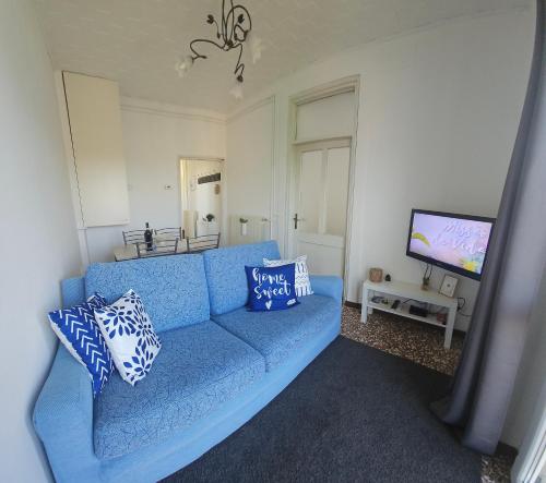 ein blaues Sofa im Wohnzimmer mit einem TV in der Unterkunft Luna Serena in Luino