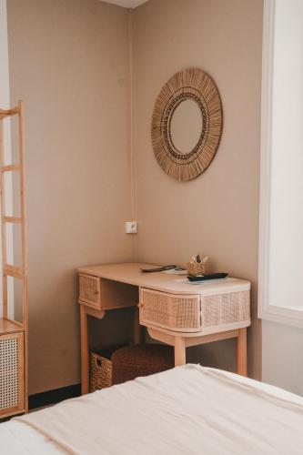 a bedroom with a desk and a mirror on the wall at L'Armoric Hôtel - RÉNOVÉ in Bénodet