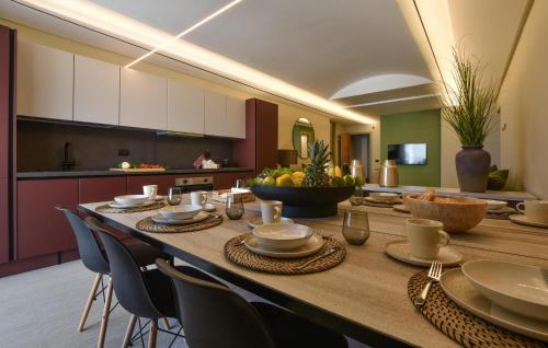 une longue table en bois avec des chaises et une cuisine dans l'établissement 5 Bedroom Stunning Apartment In Trappeto, à Trappeto