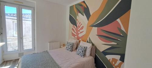 ショレにあるStudio NOTRE-DAME 2 coeur de villeの壁に絵が飾られたベッドのある寝室