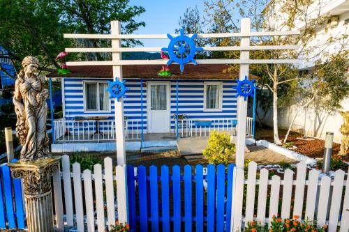a blue and white house with a cross and a fence at Devrim Apart in Ocaklar