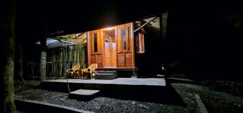 a house with two chairs and a porch at night at Rasamala Camp in Pengalengan