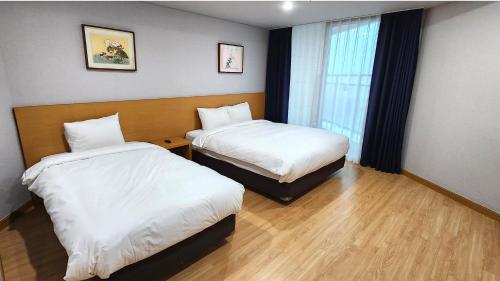 a hotel room with two beds and a window at Kwangsu Hotel Haeundae in Busan