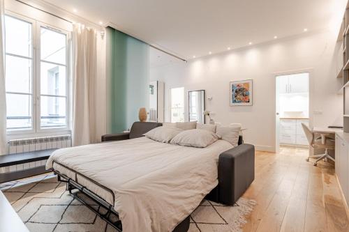 une chambre avec un grand lit et un bureau dans l'établissement Montorgueil Suite, à Paris