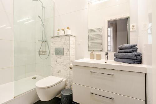 La salle de bains blanche est pourvue d'un lavabo et d'une douche. dans l'établissement Montorgueil Suite, à Paris