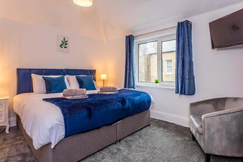 a bedroom with a bed and a window and a chair at Spacious 3 Bedroom home in Haltwhistle in Haltwhistle