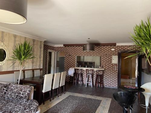 a kitchen and living room with a brick wall at Luxury apartment in private compound in New Cairo in Banī Ghālib