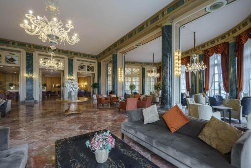 a living room with a couch and a chandelier at Eurostars Hotel Excelsior in Naples
