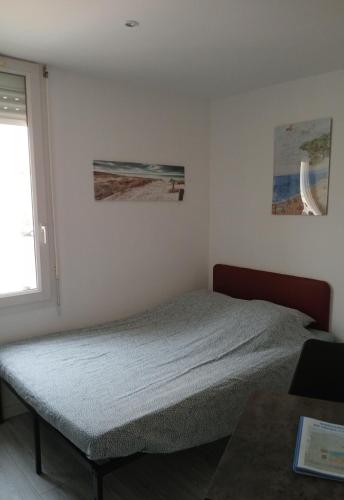 une chambre avec un lit et une fenêtre dans l'établissement Au Tromp l'oeil Studio ou T2, à Sainte-Marie-la-Mer