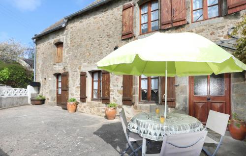 une table avec un parasol devant un bâtiment dans l'établissement 2 Bedroom Lovely Home In Saint-Lunaire, à Saint-Lunaire