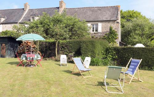 - un groupe de chaises et une table avec un parasol dans l'établissement 2 Bedroom Lovely Home In Saint-Lunaire, à Saint-Lunaire