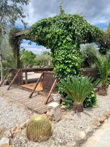 a garden with a wooden boardwalk with plants at Casa Estrella in Villafamés