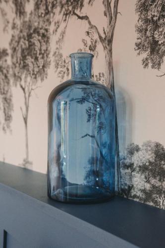 a blue glass vase sitting on top of a shelf at L'Armoric Hôtel - RÉNOVÉ in Bénodet