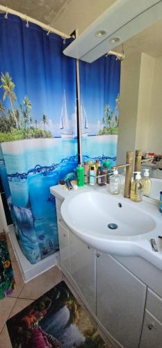 La salle de bains est pourvue d'un lavabo et offre une vue sur l'océan. dans l'établissement Charmante chambre chez l'habitant, à Cannes