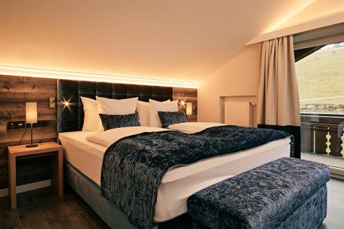 a bedroom with a large bed and a window at Natur- & Genießerhotel Der Birkenhof in Oberstaufen