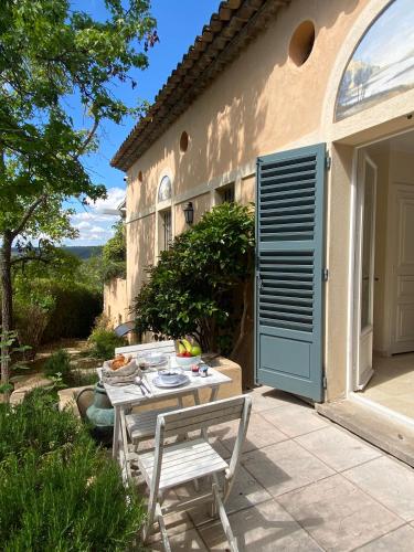 een patio met een tafel en een bank naast een gebouw bij Domaine Picasso in La Colle-sur-Loup