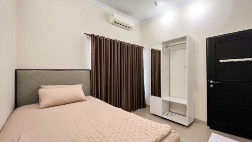 une petite chambre avec un lit et une fenêtre dans l'établissement Moona Homestay Jogja, à Gondowulung