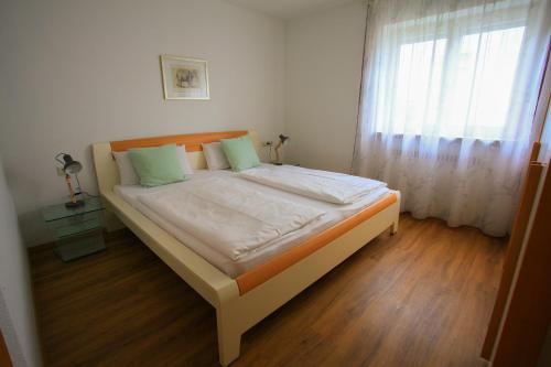 a bed in a small room with a window at Sommer-Glück in Immenstaad am Bodensee