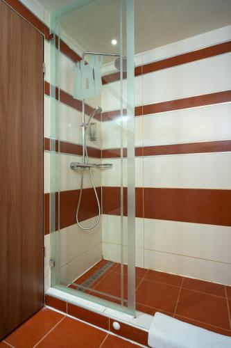a shower in a bathroom with red and white stripes at Hotel Castello & Thermal Spa Siklós in Siklós