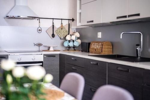 a kitchen with a sink and a counter with chairs at Holiday Villa Kallan Pore in Kalajoki