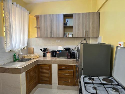 a kitchen with a refrigerator and a stove top oven at Cosy Living near Bofa Beach in Kilifi