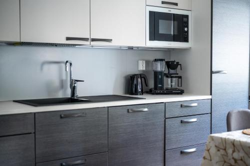 a kitchen with a sink and a microwave at Holiday Villa Kallan Pore in Kalajoki