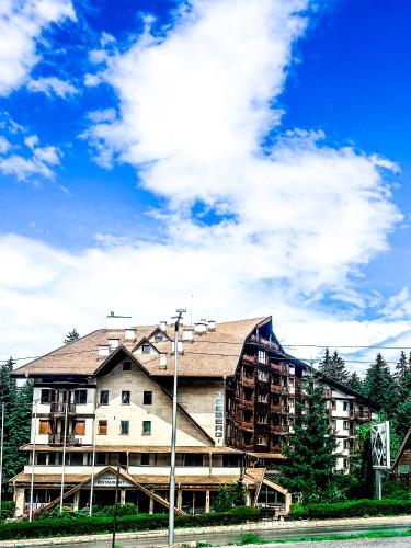 a large apartment building in front of a cloudy sky at Hotel Iceberg Borovets in Borovets