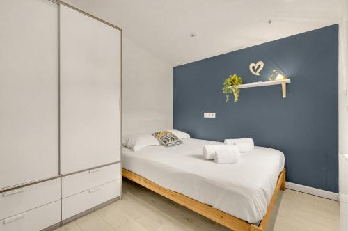 une chambre avec un lit avec un mur bleu dans l'établissement La Petite Toulousaine - T2 proche gare, à Toulouse