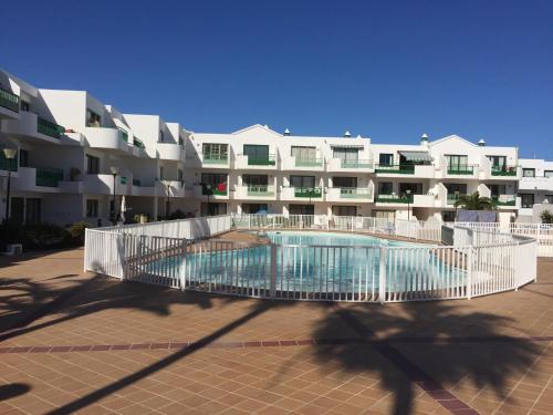 a building with a swimming pool in front of a building at Casa Linda in Costa Teguise