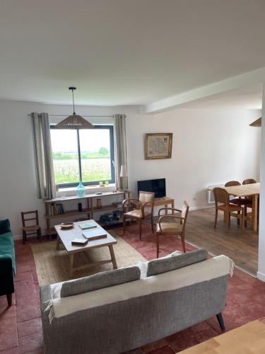 a living room with a couch and a table at Maison des Vendanges in Cesset