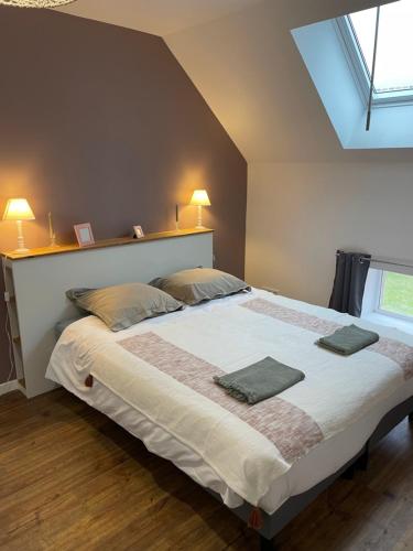 a bedroom with a large bed with two pillows on it at Maison des Vendanges in Cesset